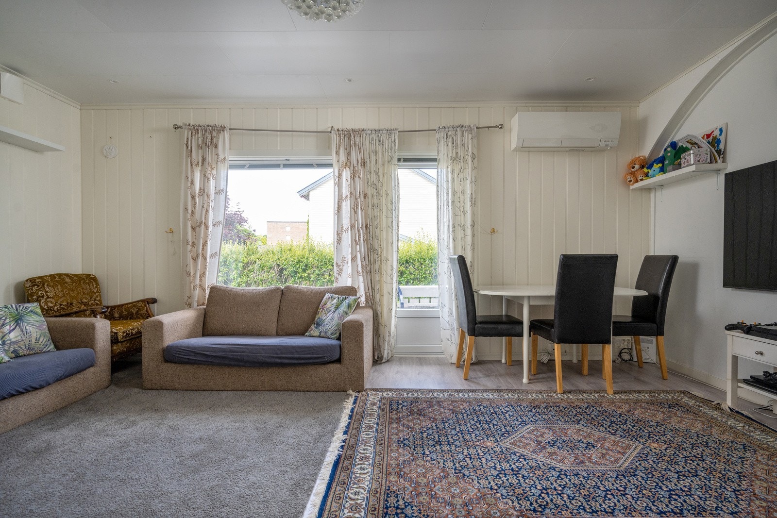 Lys stue med mye lysinnslipp. Utgang til vestvendt veranda. Galleribilde