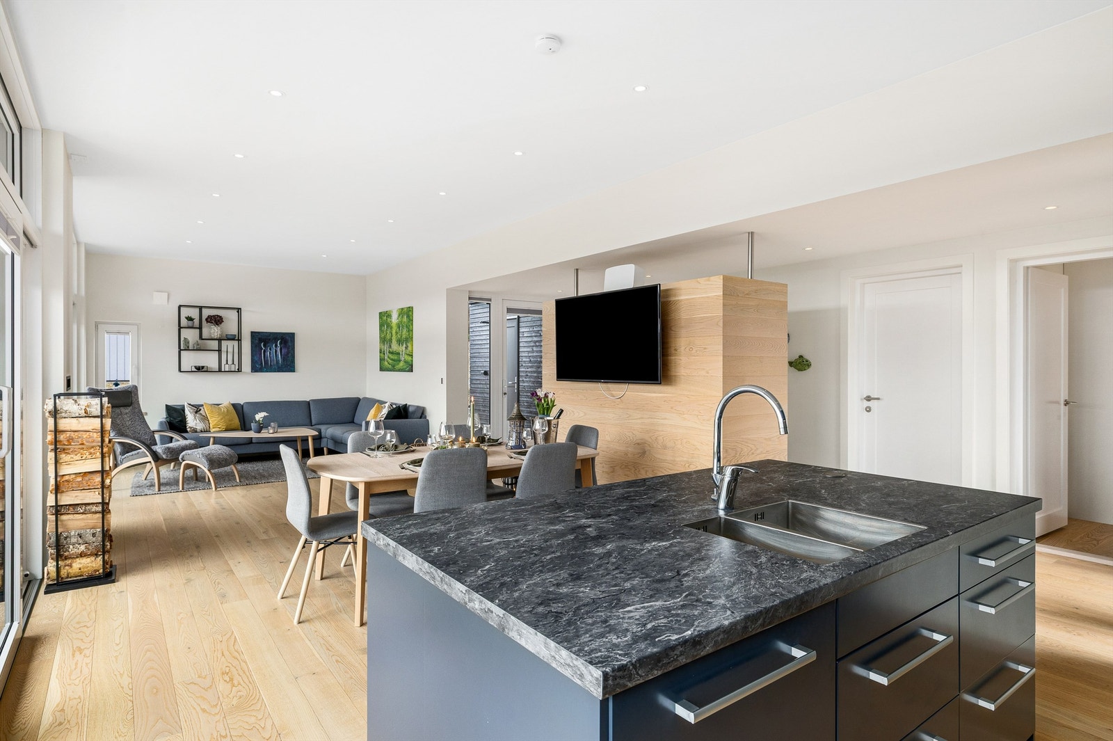 Bakveggen til garderobeskapet i gangen er i samme materiale som gulvet og gir plass til TV - her er det ingen unødvendige detaljer som forstyrrer de stramme, rene linjene. Galleribilde