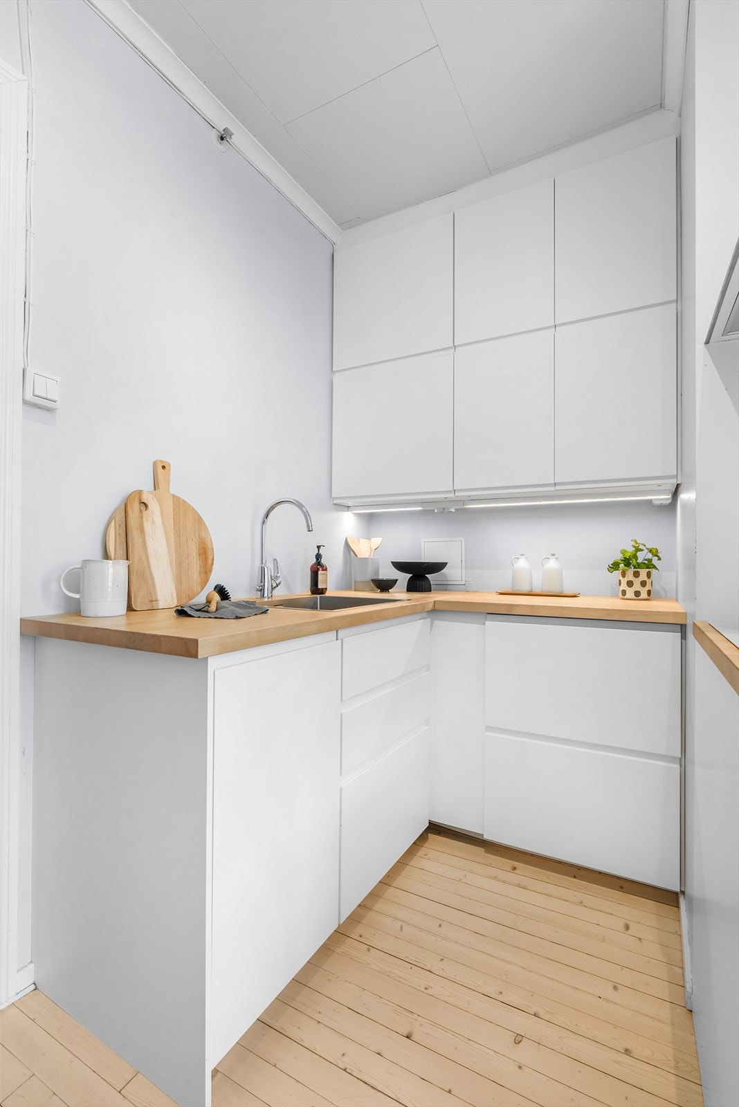 Kjøkkeninnredningen har glatte fronter og en elegant benkeplate av tre, som skaper et tidløst uttrykk. Galleribilde