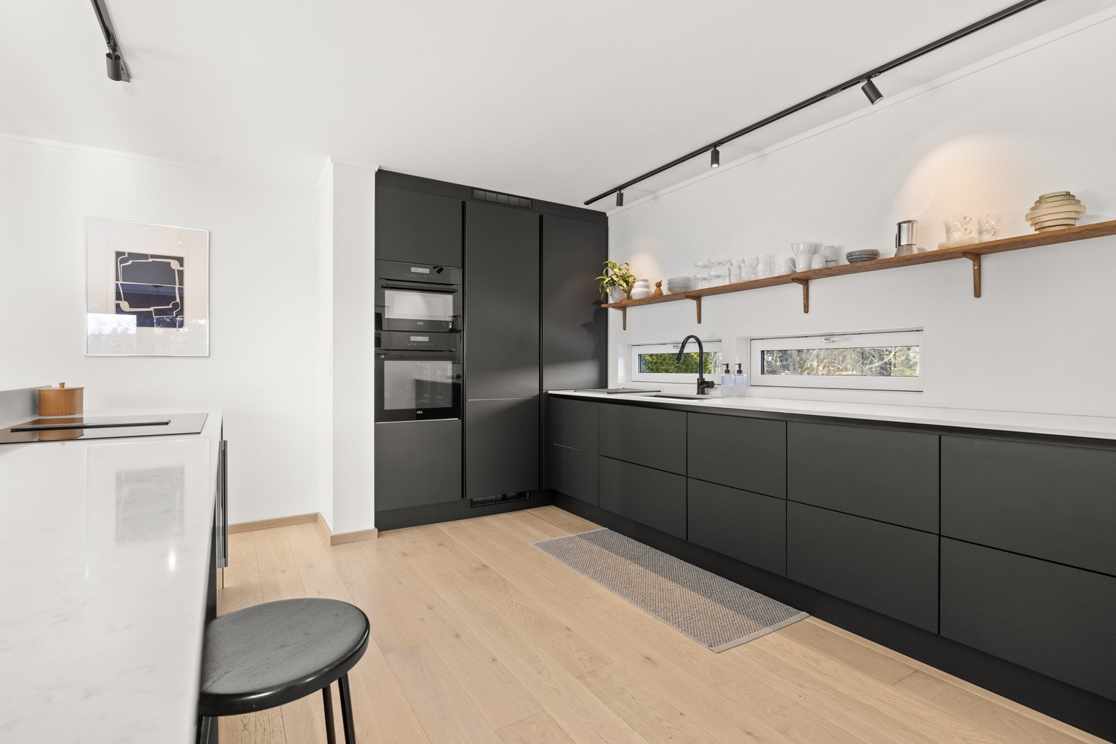 Kvalitetskjøkken fra HTH med integrerte hvitevarer fra AEG og Miele. Lekker hylle i heltre eik over kjøkkenbenken og spotskinner i taket. Galleribilde