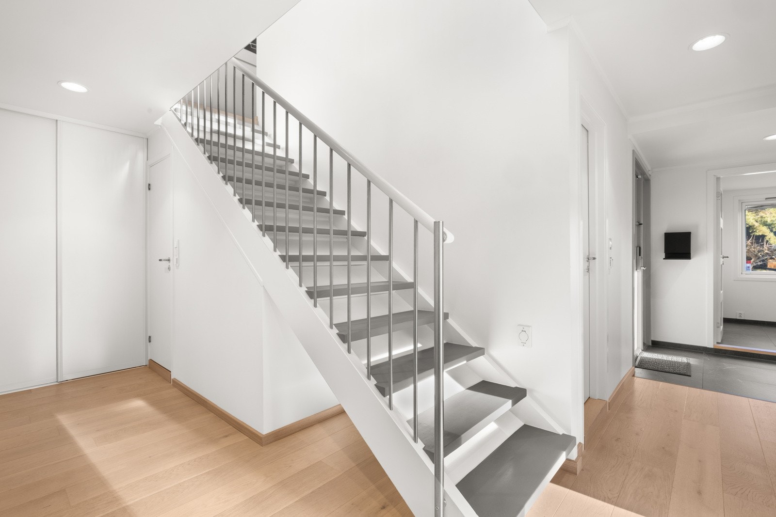Lyst og åpent trapperom i første etasje med garderobeløsning. Galleribilde