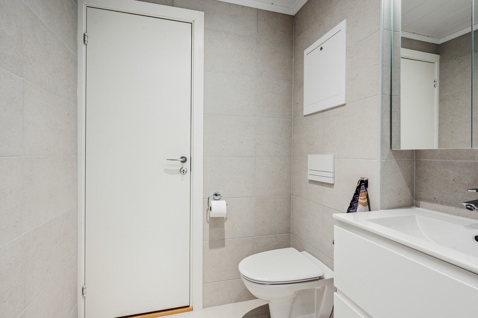 Badet har dusjhjørne med foldedører av glass og gulvvarme Galleribilde