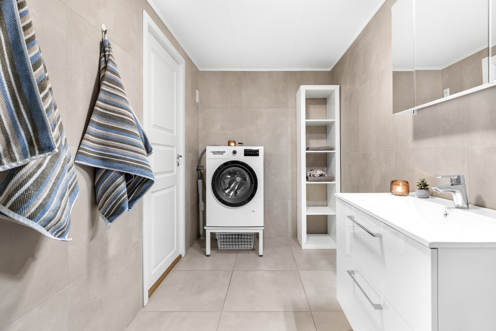 Rommet er innredet med vegghengt servantinnredning, speilskap med overlys og dusjhjørne med regndusj Galleribilde
