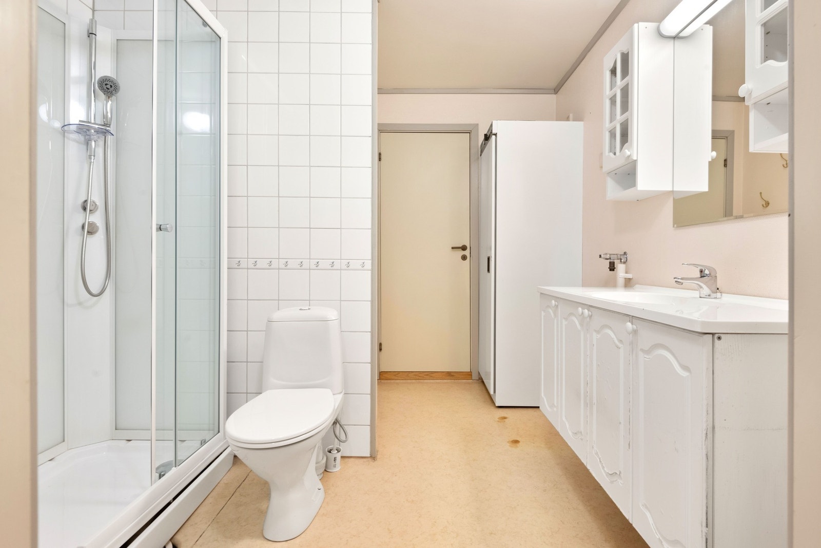 Første badet har adkomst fra kjøkkenet og garderoben. Badet har gulvbelegg, malt strie på vegger og fliser i dusjområdet. Galleribilde