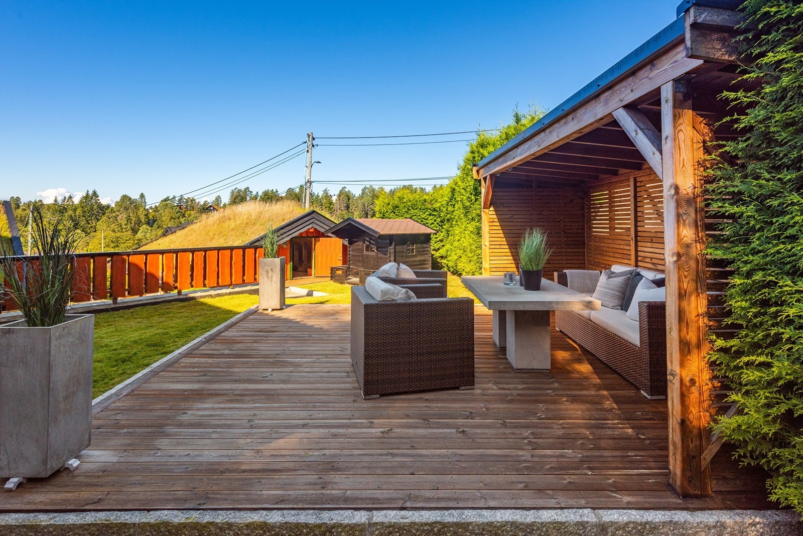 Uteplass med pergola på terrasse omrammet med kantstein i granitt Galleribilde