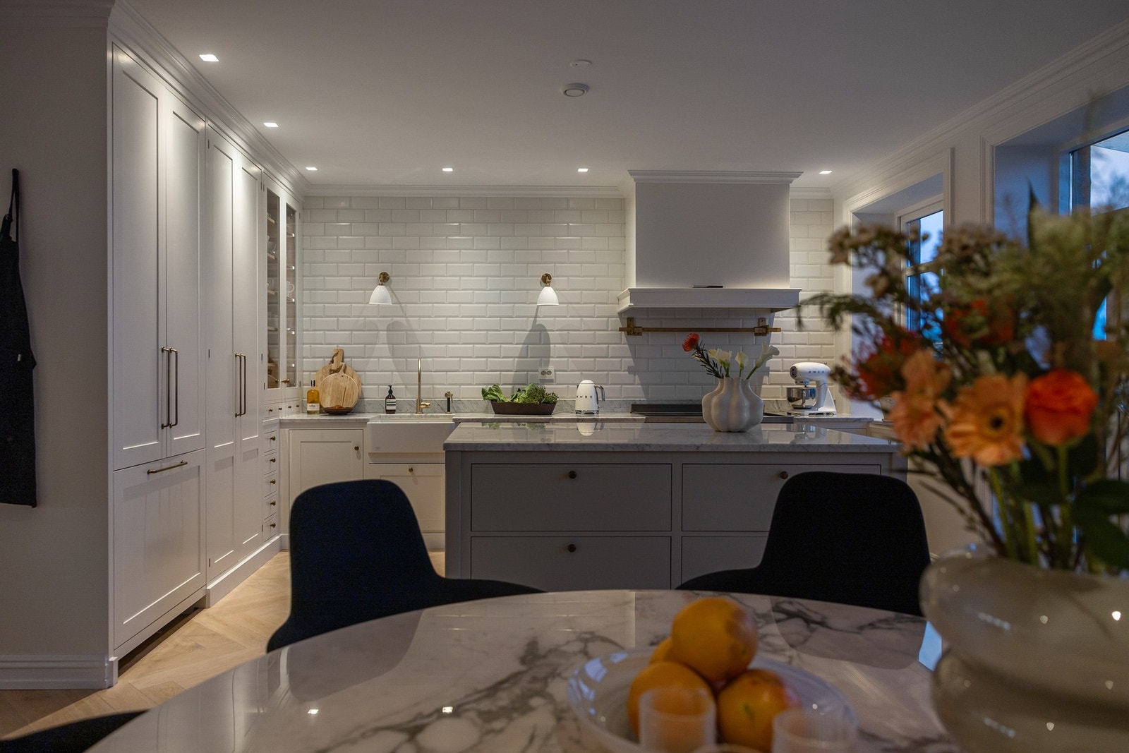 Rommet har ellers en detaljrik og kledelig Kvänum innredning i hvitt med profilerte, heltre fronter, vitrineskap og marmor benkeplater. Galleribilde