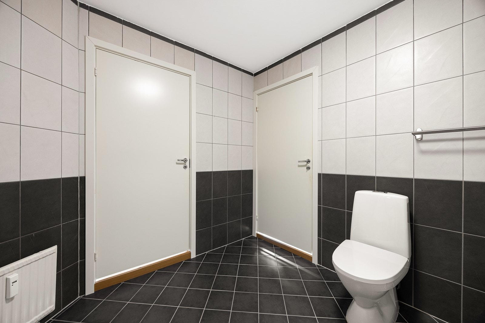 Badet er utstyrt med dusjkabinett, servant med underskap, speil, høyskap, opplegg for vaskemaskin og WC Galleribilde