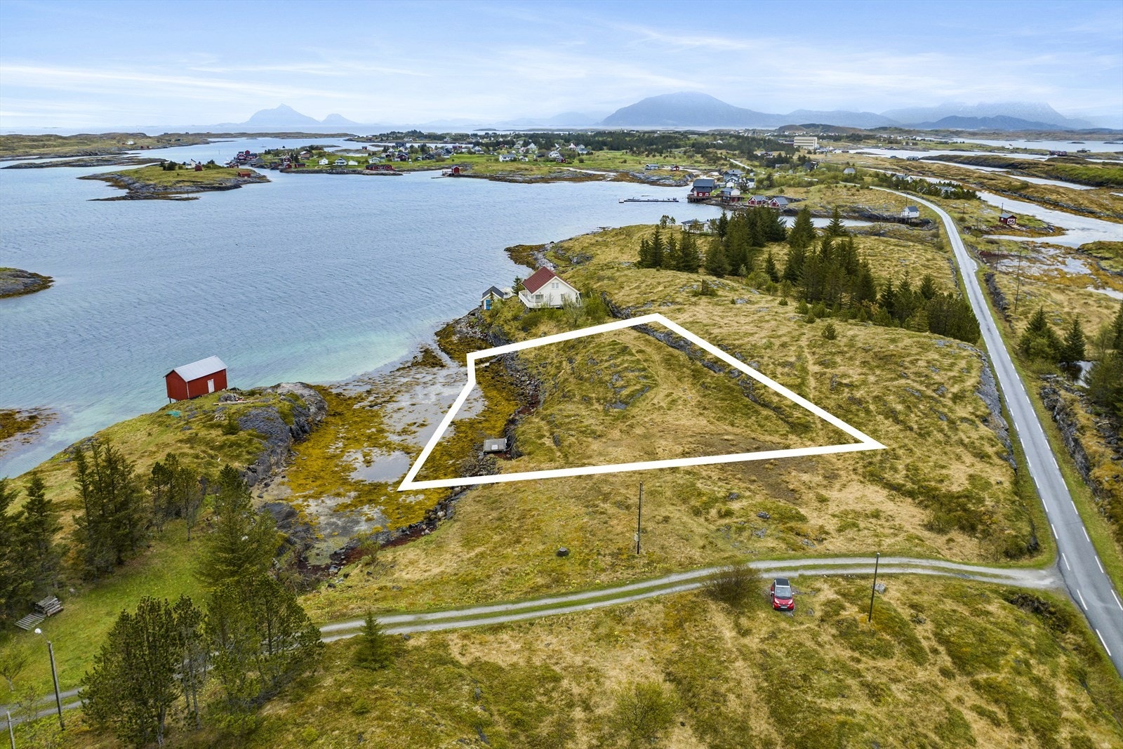 Hyttetomt på Sleneset med majestetisk utsikt vest og nord mot Lovund og Trænfjorden. Fiktive grenser satt opp av fotoleverandør og må ikke betegnes annet en illustrasjon, sjekk grunnkart for nøyaktig grensebeskrivelse. Lagt nytt 31.07.2023. Galleribilde