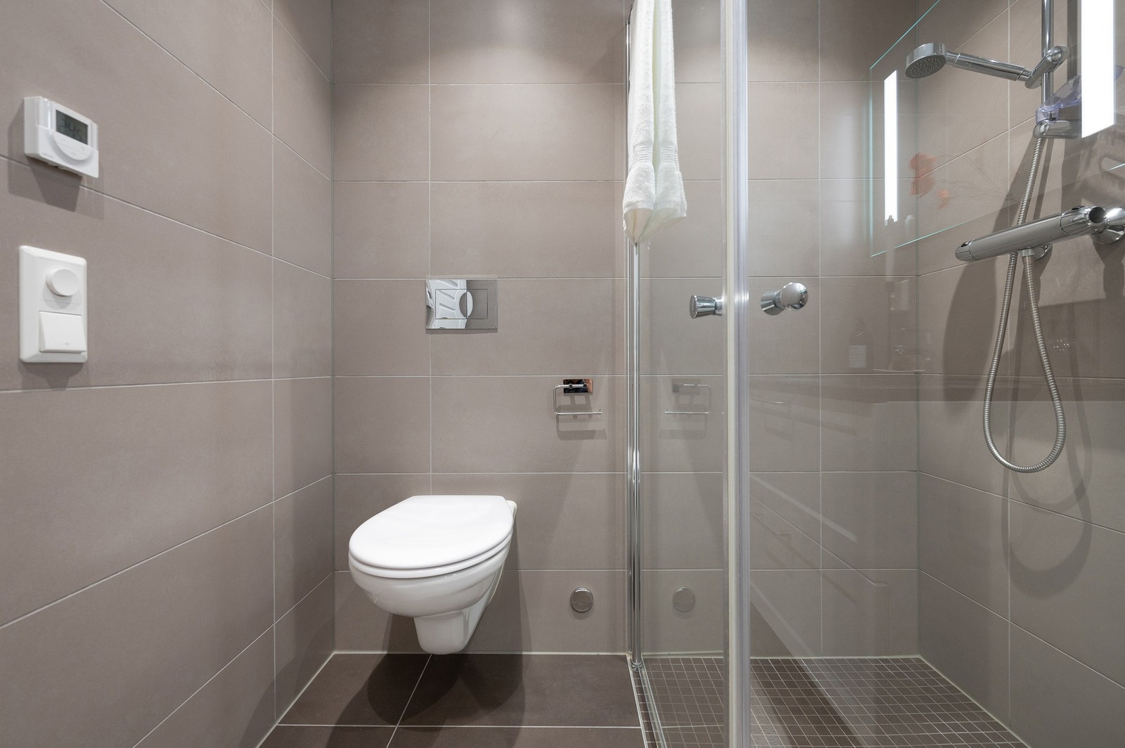 Tiltalende bad med hvit innredning med servant, wc og dusj. Gulvarme. Galleribilde