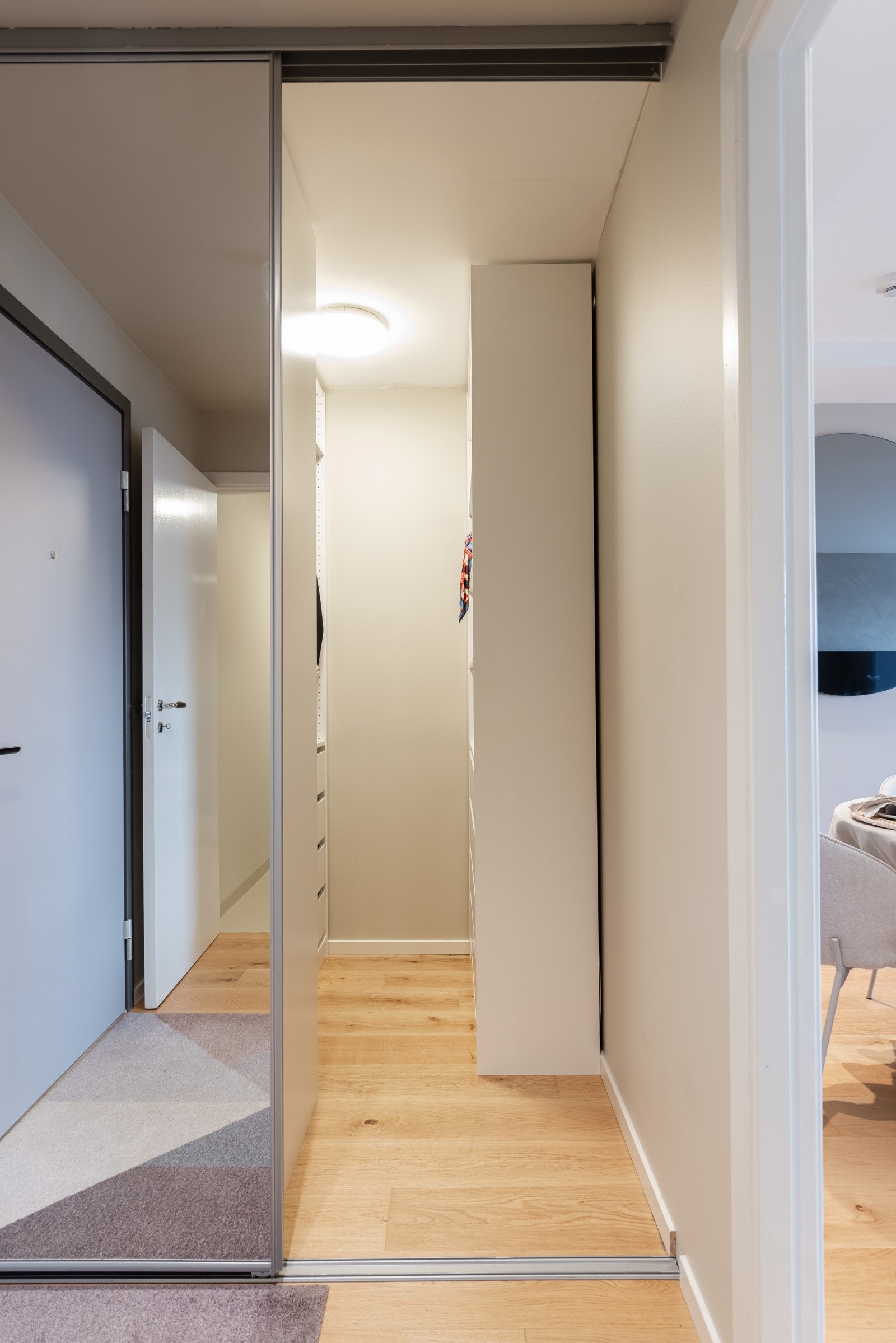 Romslig og praktisk omkledningsrom med adkomst fra entré fra skyvedører med speil. Galleribilde