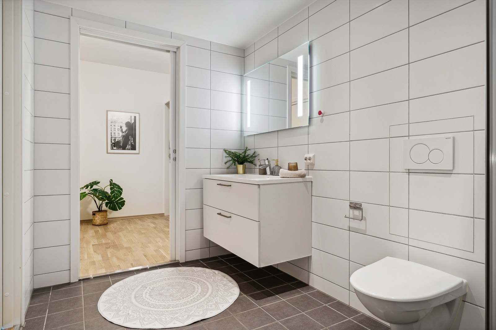 Pent baderom med tidløse fliser og behagelig vannbåren gulvvarme. Galleribilde