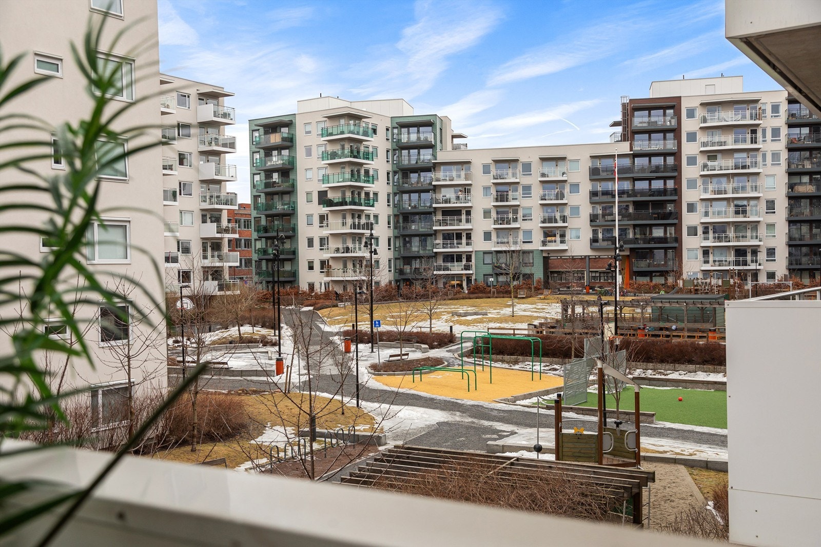 Balkongen har utsikt mot bilfri tomt med aktivitetspark. Galleribilde