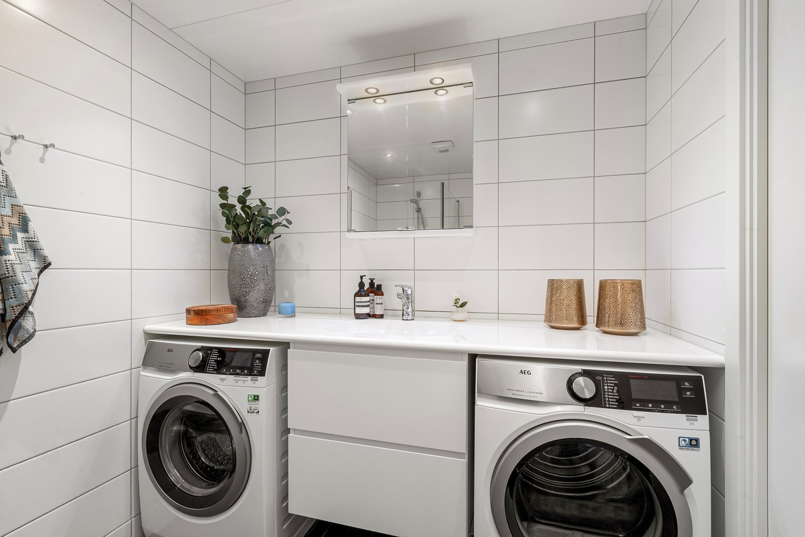 Dusjbad/wc (ca. 5 kvm): Heldekkende benkeplate med integrert servant. Praktiske skuffer og plass under benkeplate til vaskemaskin og kondenstørke-trommel. Galleribilde