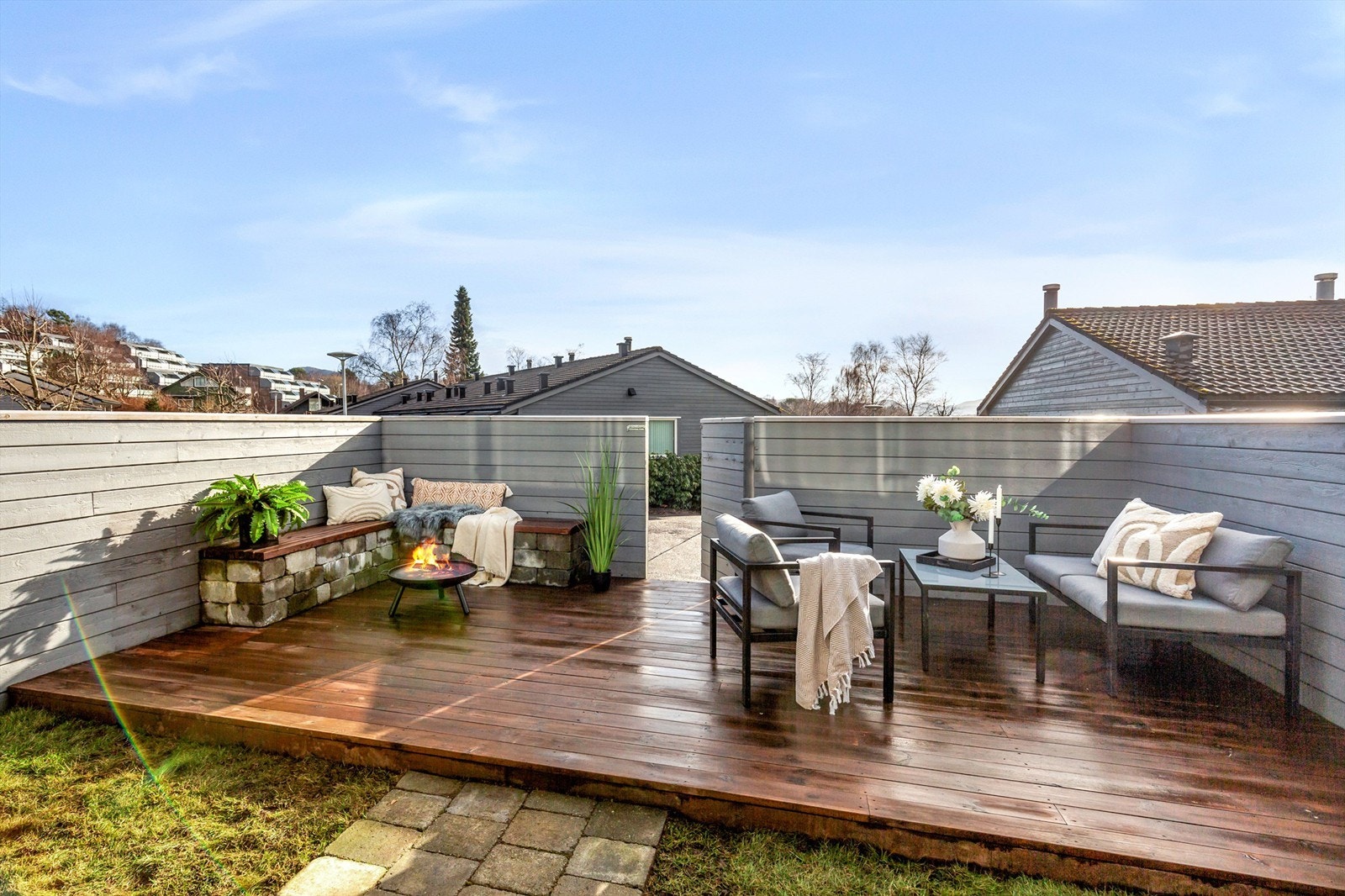 En koselig uteterasse med komfortable utemøbler og en varmende bålpanne, perfekt for sene sommerkvelder med venner og familie. Galleribilde