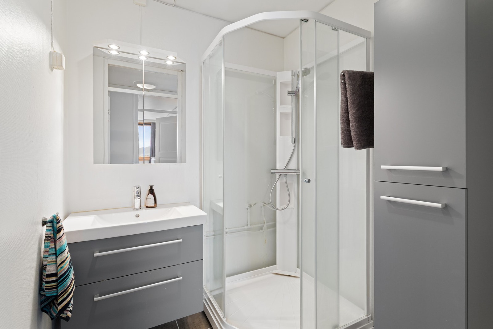 Utstyrt med dusjkabinett og servant i skap. Galleribilde