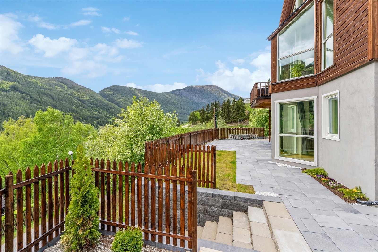 Eiendommen har flotte utearealer med fine forstøtningsmurer og steinlagte områder i forkant av boligen. Galleribilde