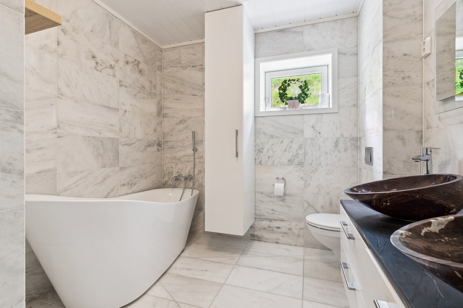 Innbydende bad med marmorfliser på veggene. Galleribilde