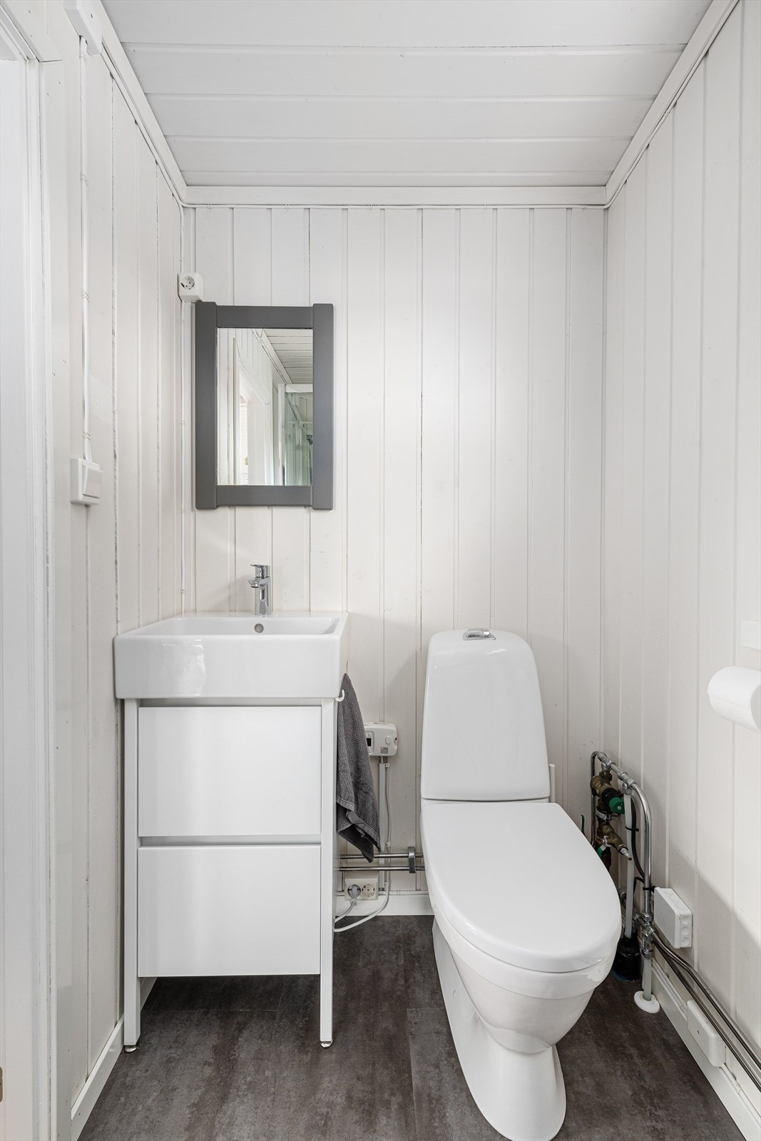 Baderommet er ikke stort, men rommer likevel både wc, servantseksjon, dusjkabinett og opplegg til vaskemaskin. Galleribilde