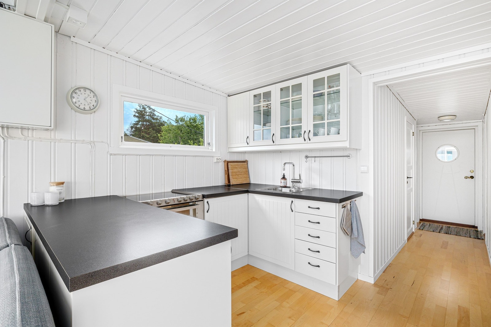 Legg merke til inngangsdøra med rundt vindu. Slike vinduer kalles for "koøye" når de er ombord i et fartøy. Galleribilde