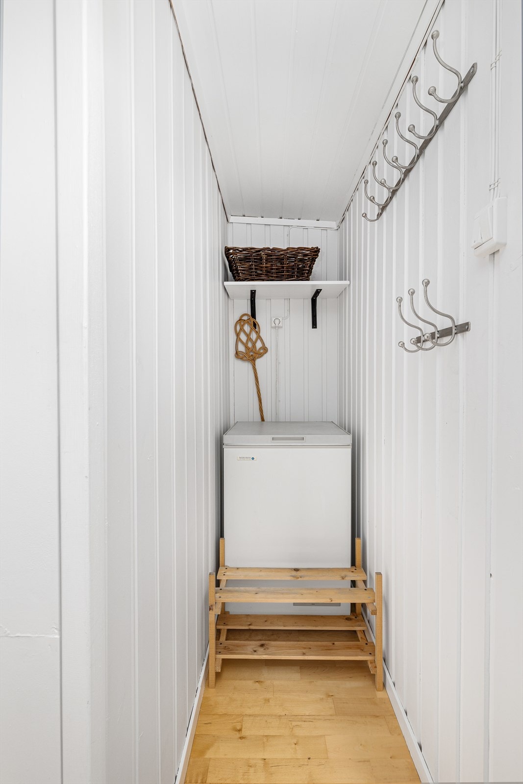 Praktisk plass i gangen til å henge fra seg tøy, samt ekstra plass til en fryseboks. Galleribilde