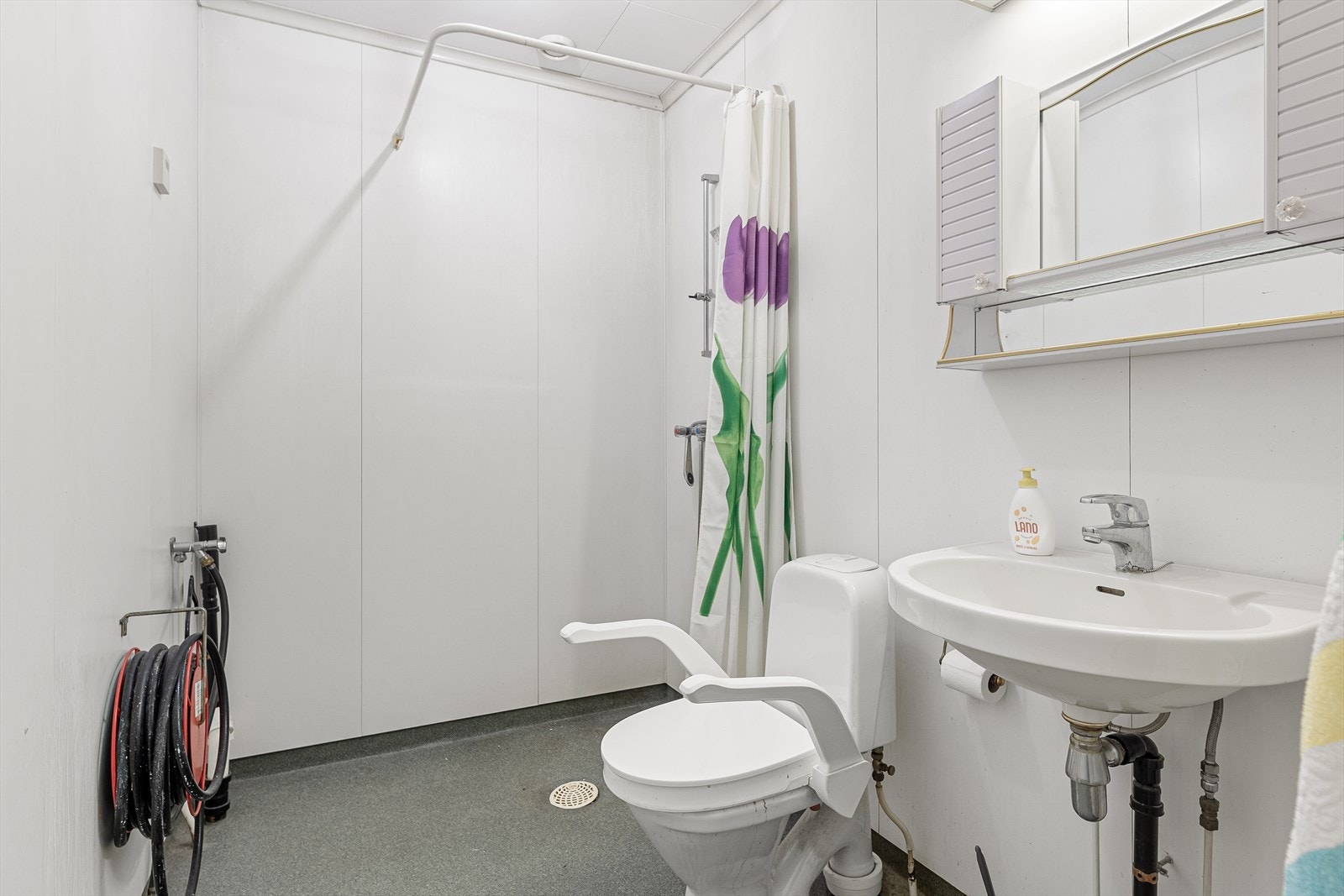 Badet fremstår med eldre konstruksjoner. Det er dusjplass, servant med speil og lys over, samt opplegg for vaskesøyle og WC. Galleribilde