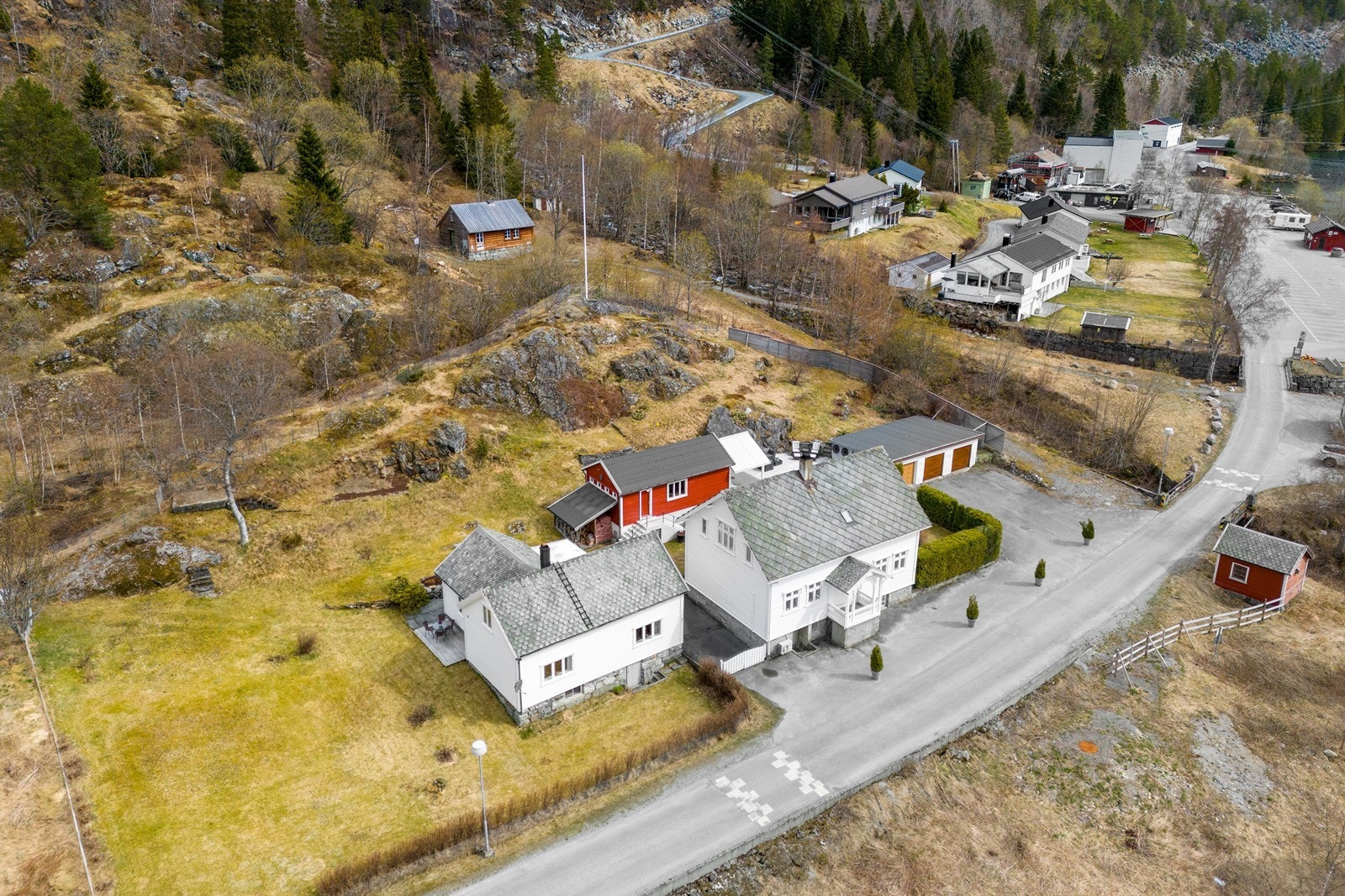 Innholdsrik eiendom med to bolighus, trippelgarasje og uthus på romslig tomt Galleribilde