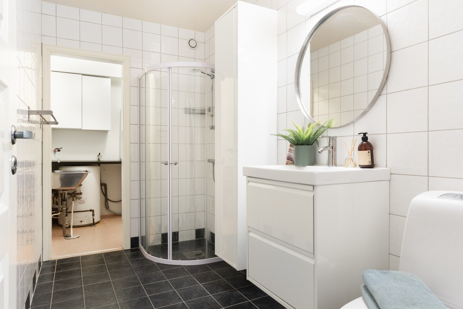 Badet er helfliset og måler 5,2 kvm. Her finner du en flott fargekombinasjon med mørkt gulv og lyse vegger. Galleribilde