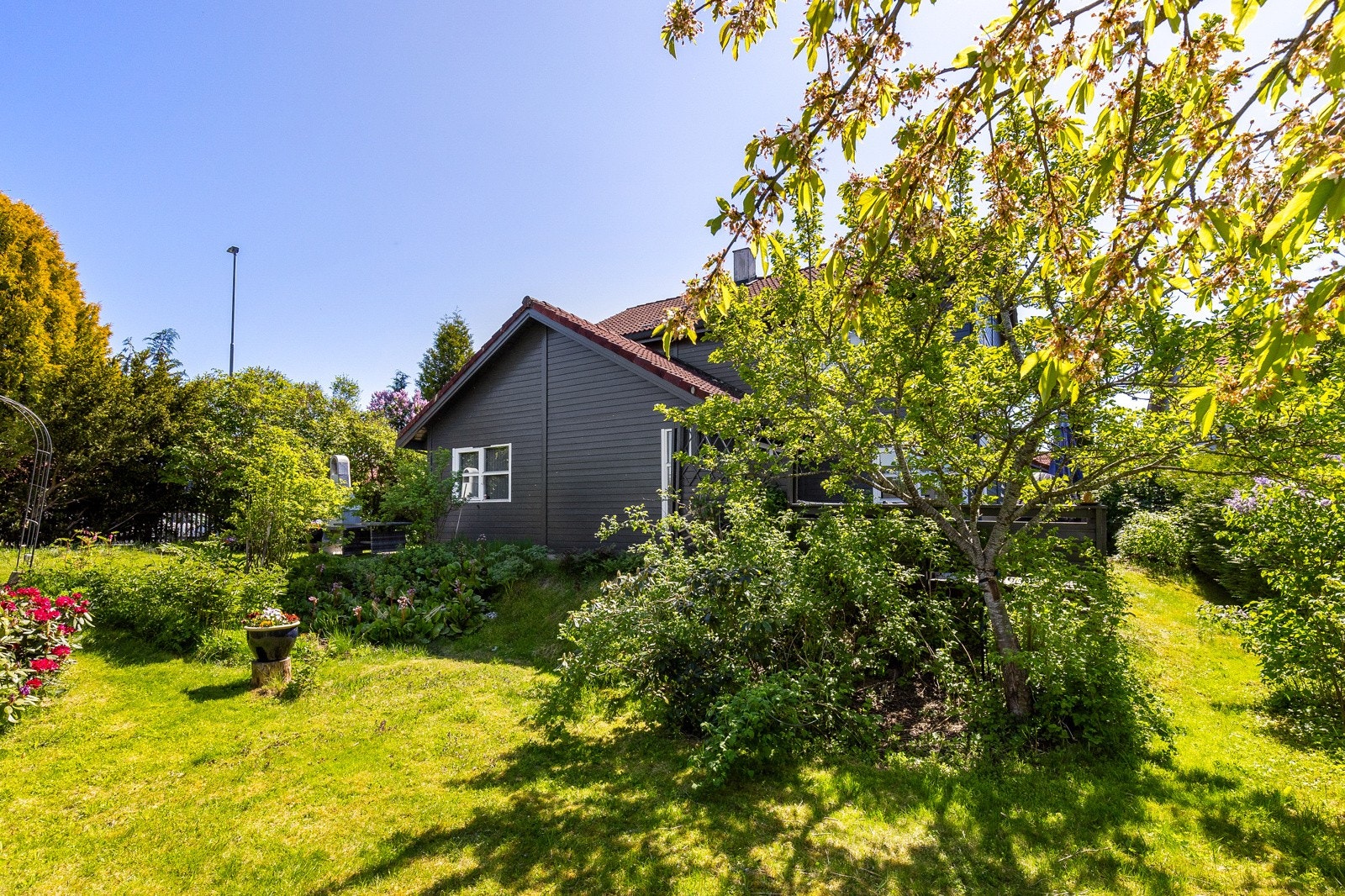 Boligens utvendige arealer er videre pent opparbeidet med gressplen, beplantning og trær Galleribilde