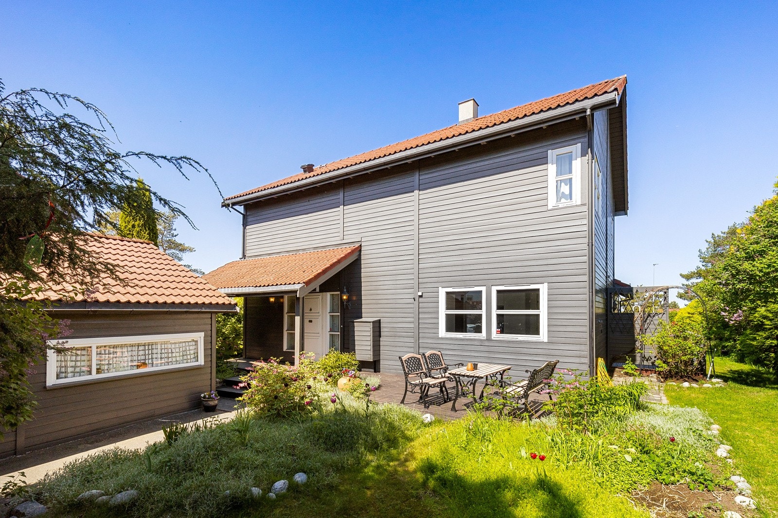 Eiendommen har flotte utearealer, med terrasser og hageområder Galleribilde