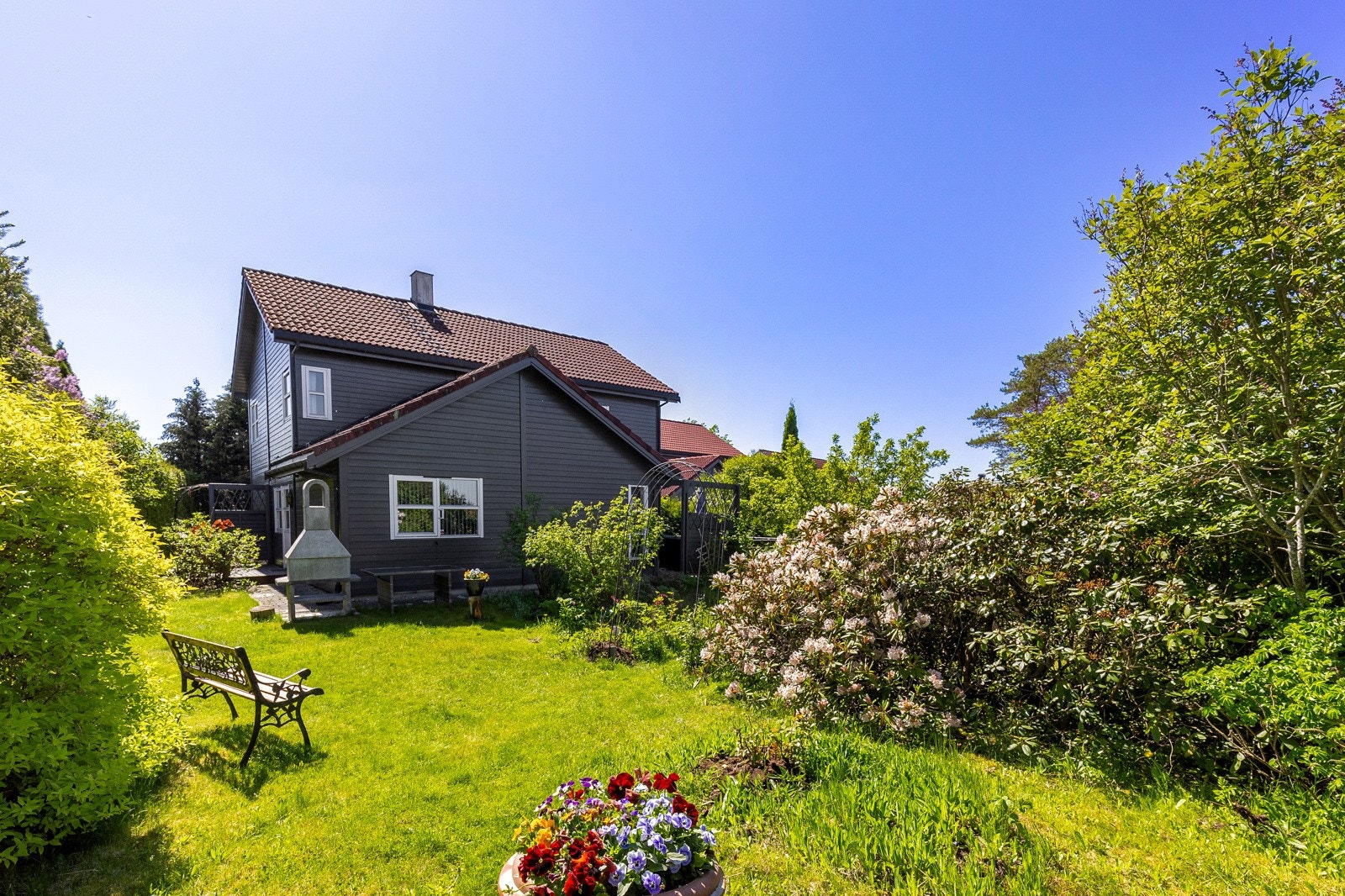 Boligen har flotte utendørsarealer, med terrasser og hage Galleribilde