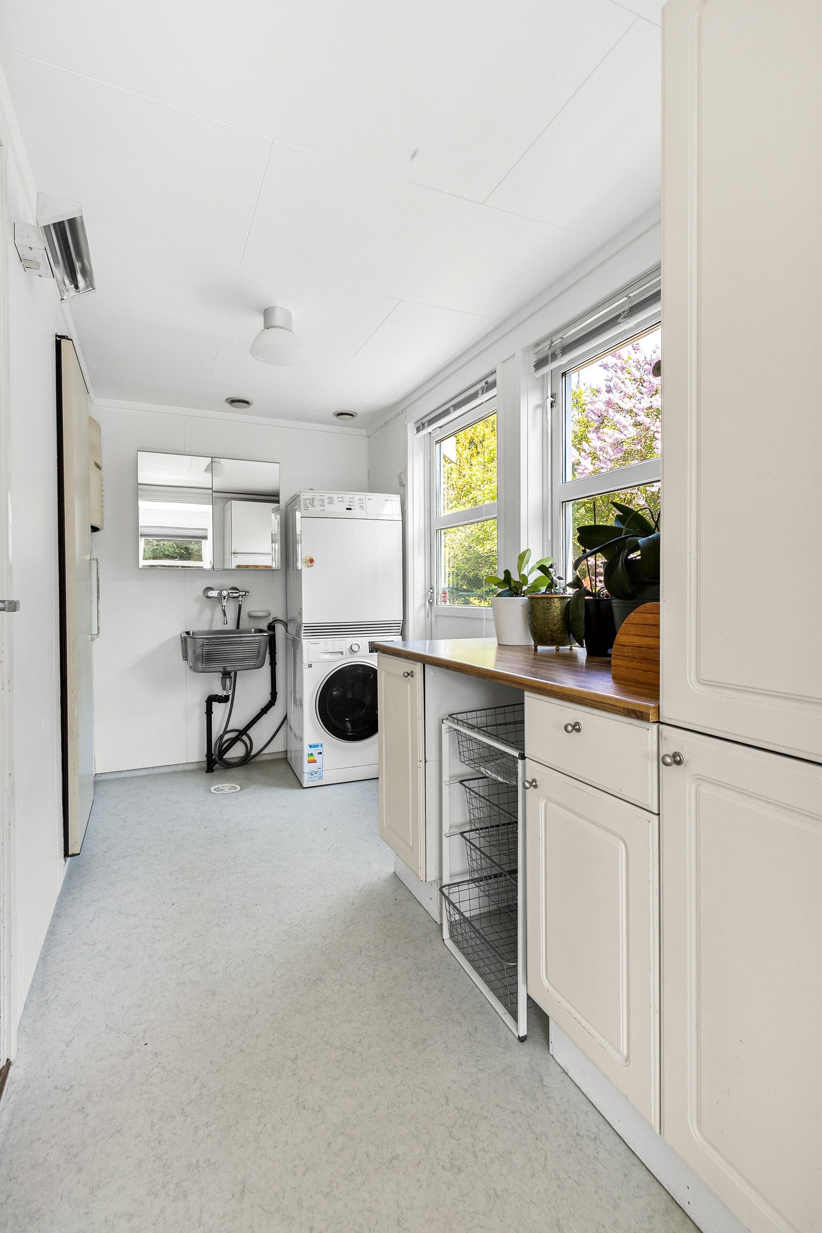 Vaskerom utstyrt med innredning med hvite profilerte fronter, benkeplate i laminat, utslagsvask, speilskap og plass for vaskemaskin Galleribilde