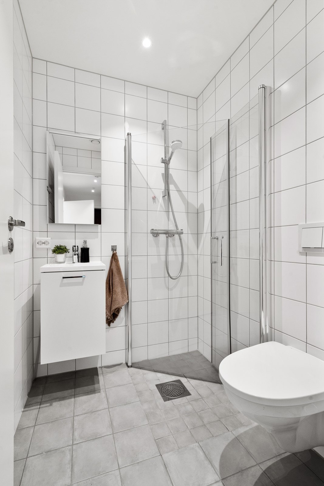 Bad 2. Flislagt gulv med gulvvarme og flislagte vegger. Vegghengt toalett og servantinnredning. Galleribilde