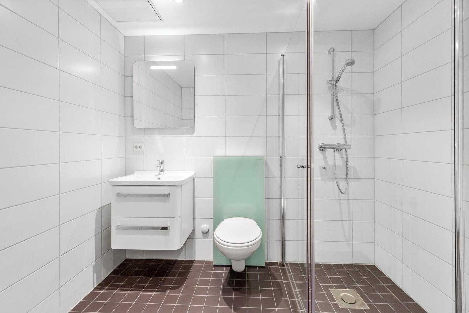 Lekkert flislagt bad i tidløse farger. Vaskemaskin og tørketrommel følger med. Galleribilde