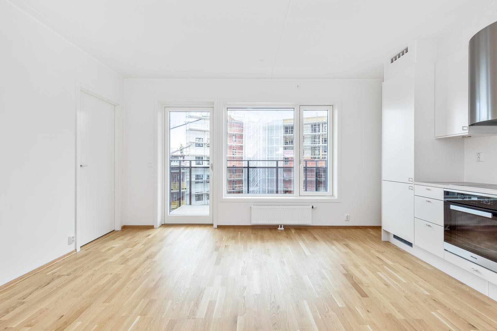 Utgang til solrik balkong. Bygget på motsatt side er ferdigstilt. Galleribilde