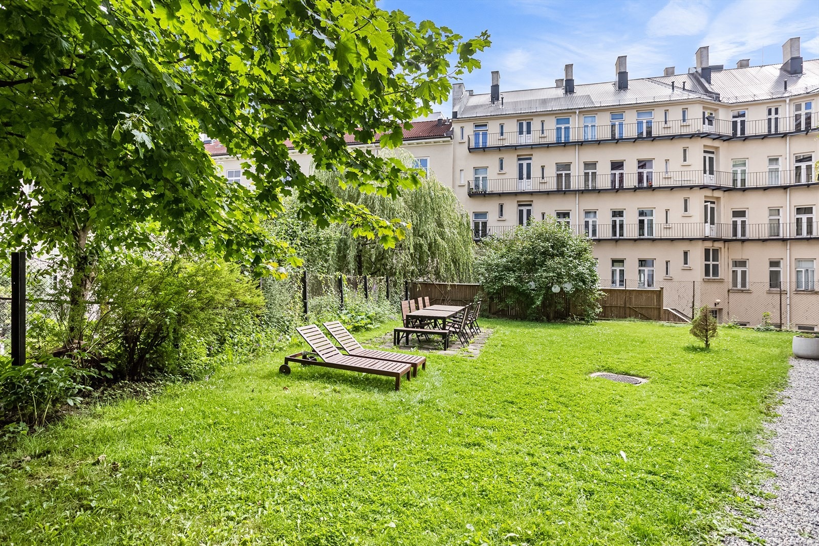 Bakgården er pent opparbeidet med plen, beplanting og internveier. Galleribilde