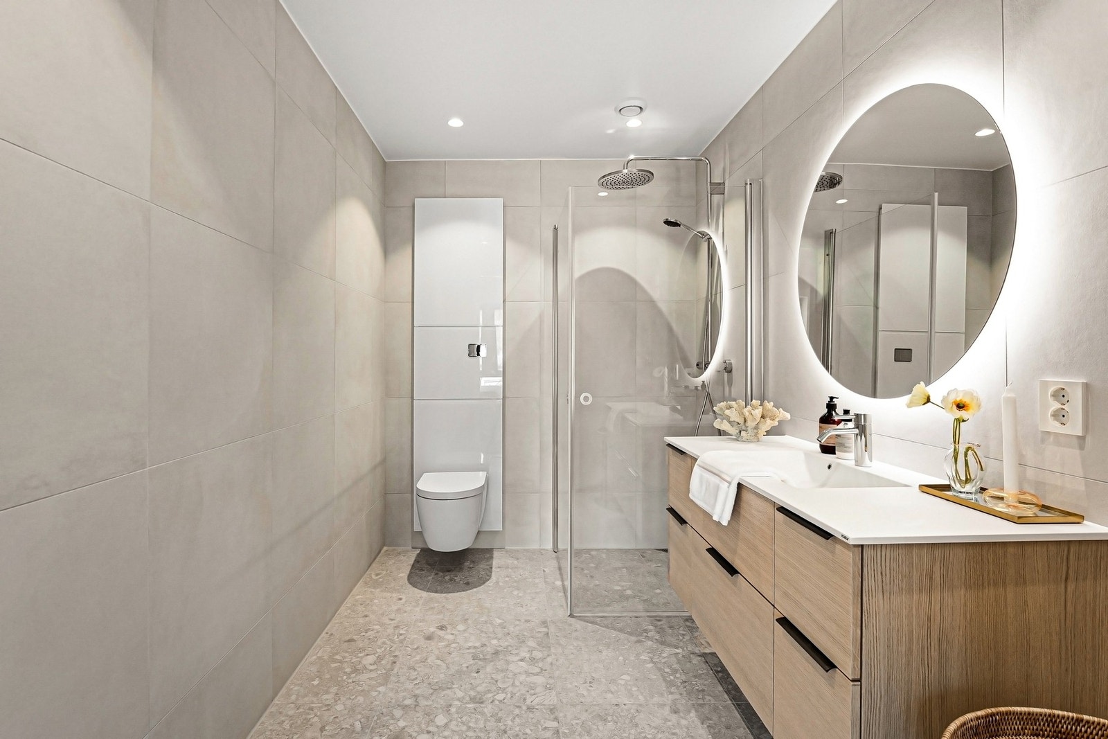 Baderom med lyse og delikate 60 x 60 fliser og baderomsinnredning i eikefiner med underskuffer Galleribilde