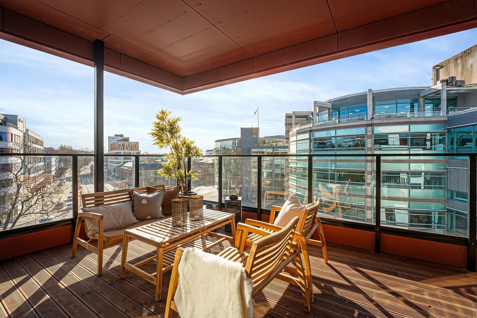 Balkongen er lun og romslig med plass til sosial møblering Galleribilde