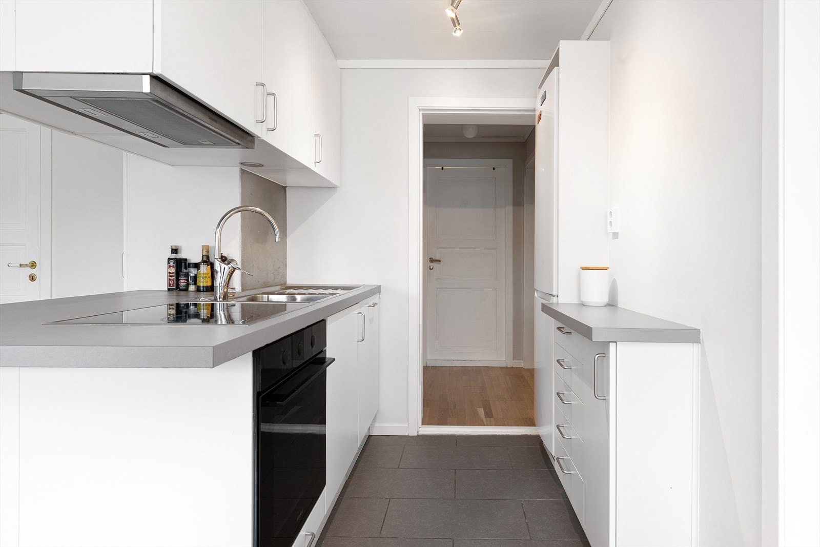 Kjøkkenet har glatte, hvite fronter med benkeplate av laminat. Galleribilde