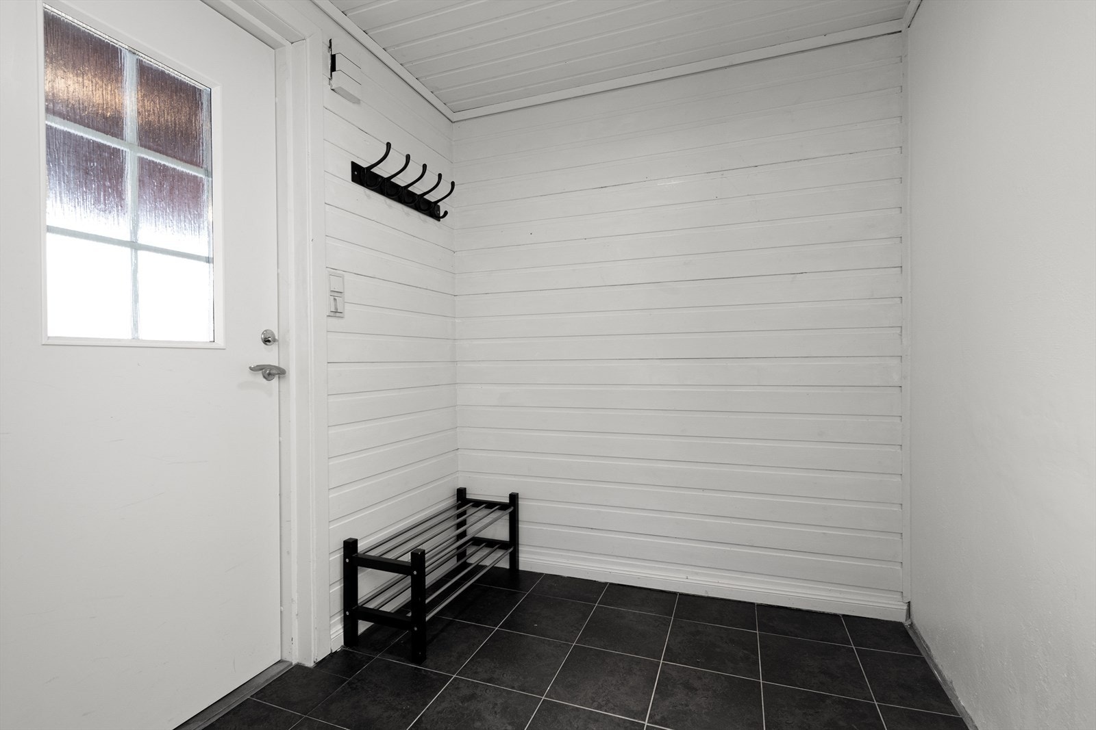 Boligens entré har flislagt gulv med varme og oppheng for ytterklær. Galleribilde