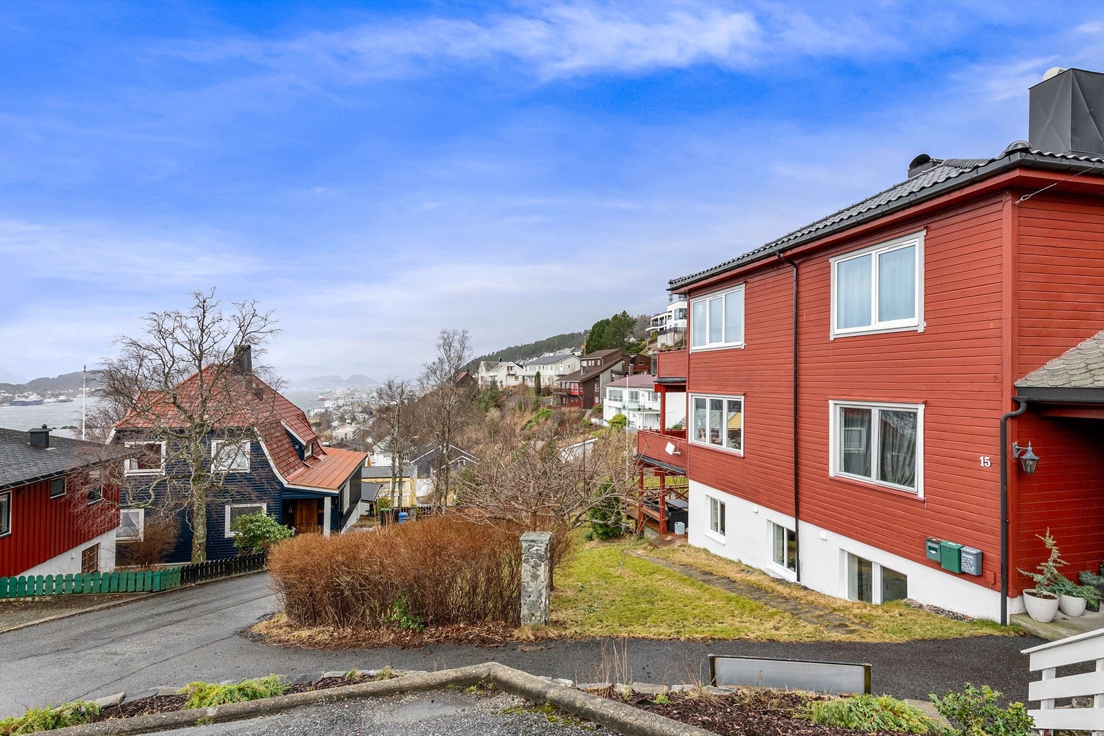 Asfaltert biloppstillingsplass med sti ned mot leiligheten. Galleribilde