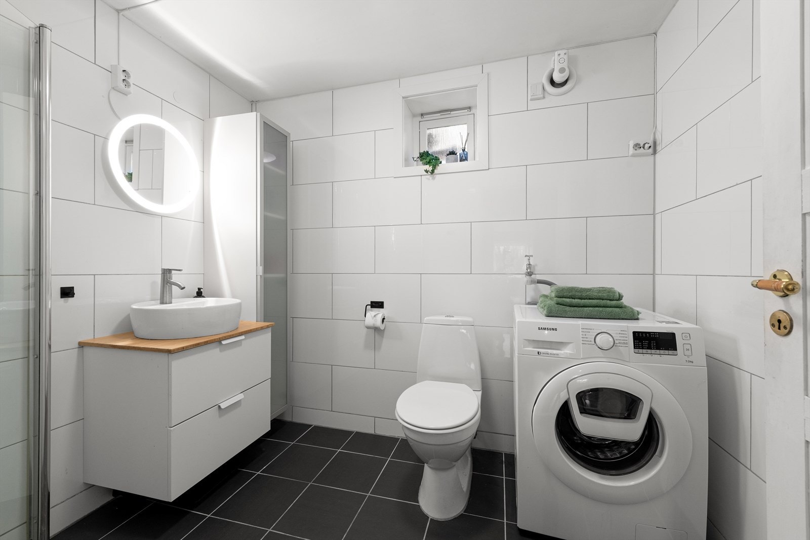 Flislagt bad med gulvvarme, elektrisk el-vifte og tilluftspalte ved dør. Galleribilde