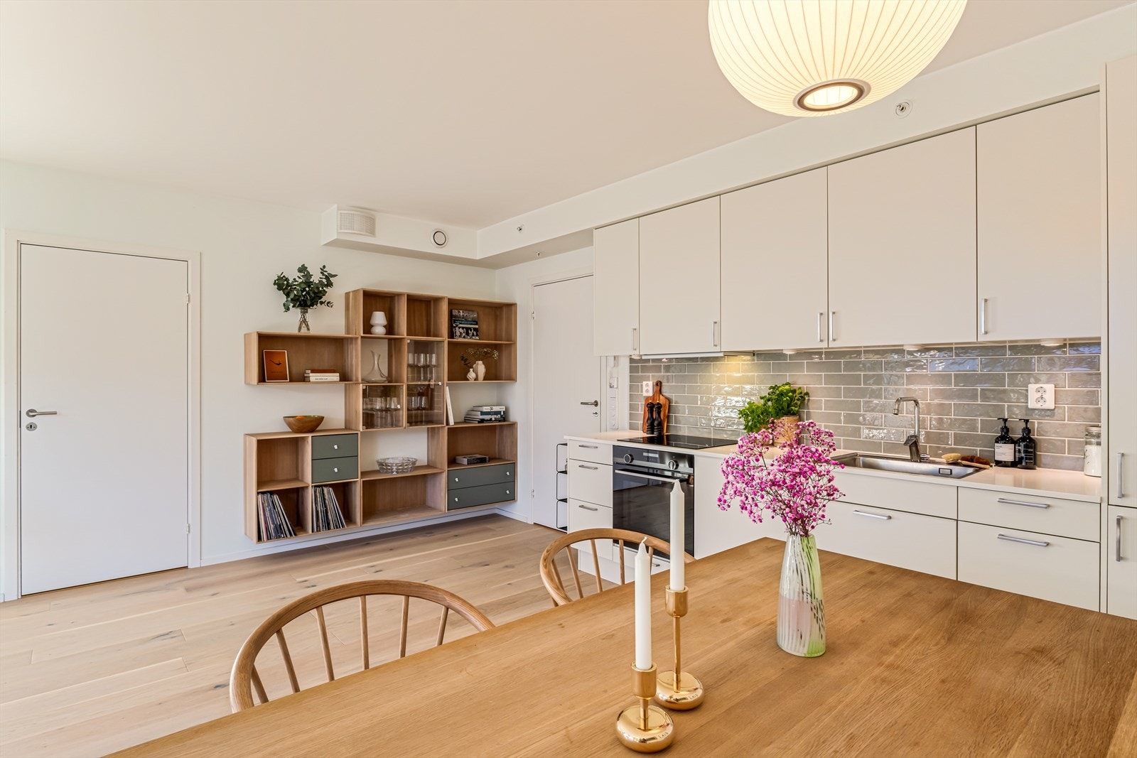 Kjøkkeninnredningen fra Norema har en stilren utførelse med glatte fronter, kompositt benkeplate og integrerte hvitevarer. Galleribilde