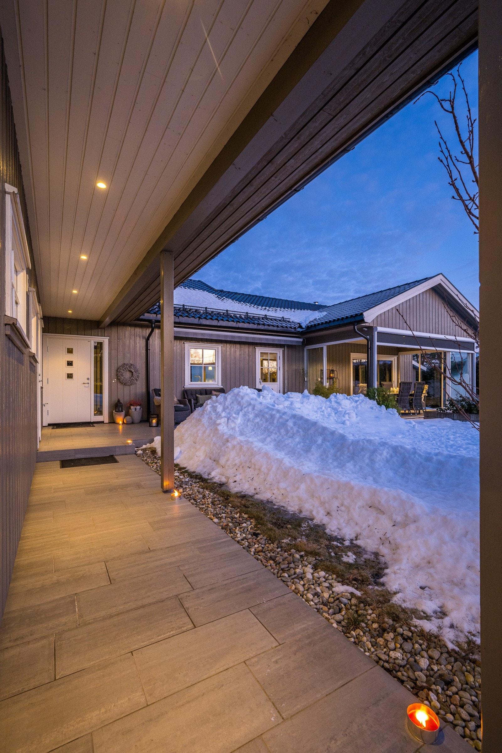 Overbygget og flislagt parti inn til inngangsdøren Galleribilde