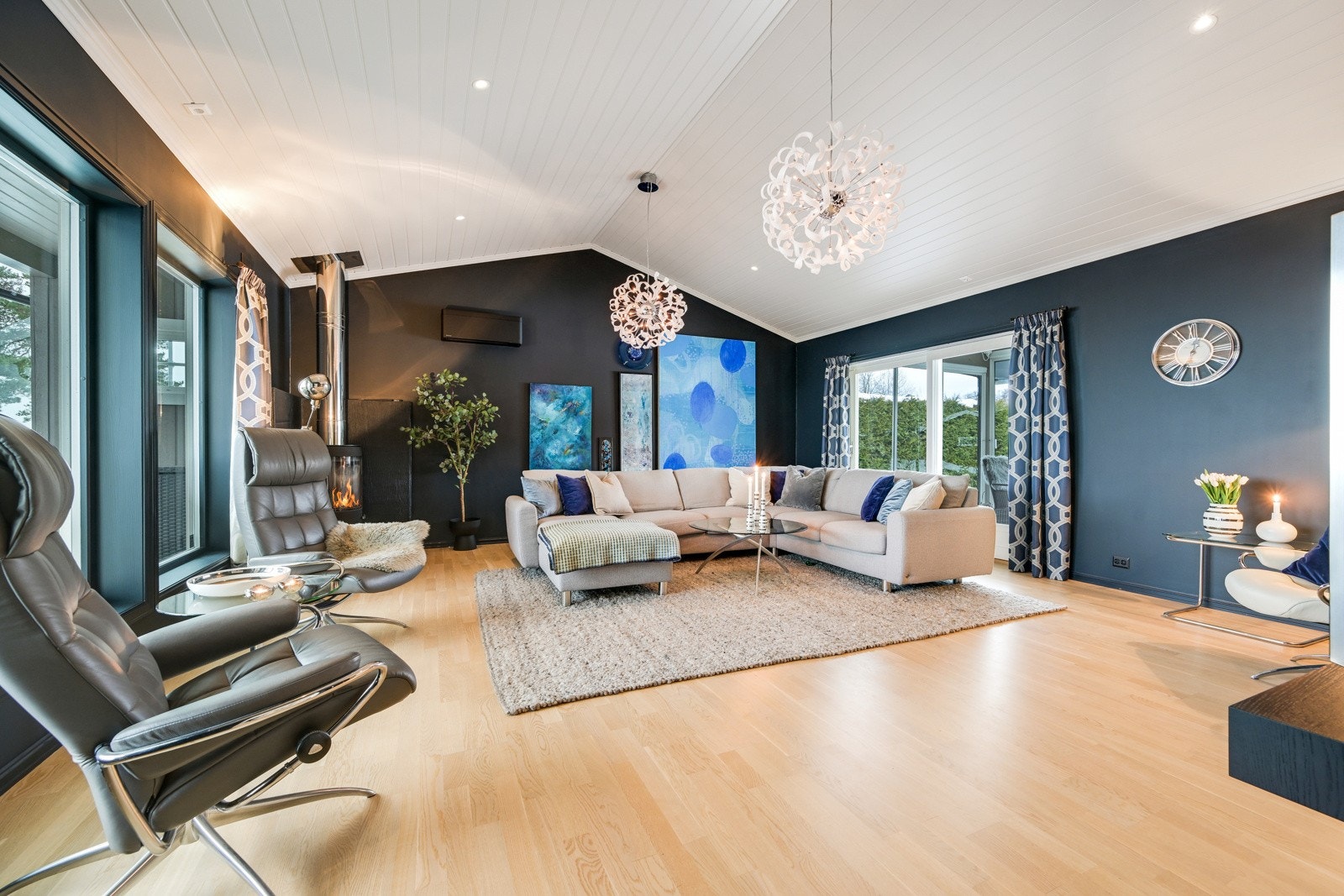 Den avslappende stemningen understrekes av vegger malt i en mørk og trendy blåfarge Galleribilde