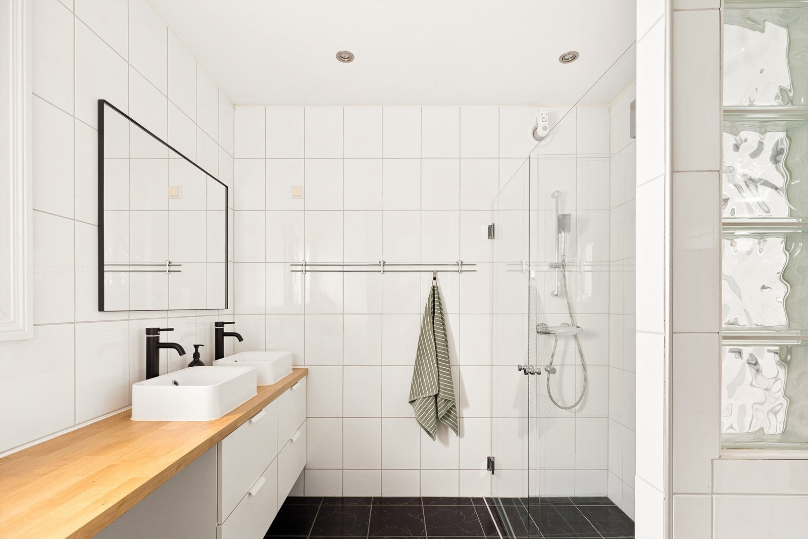 Badet i første etasje er romslig med grå gulvfliser, hvite veggfliser og gulvvarme. Galleribilde