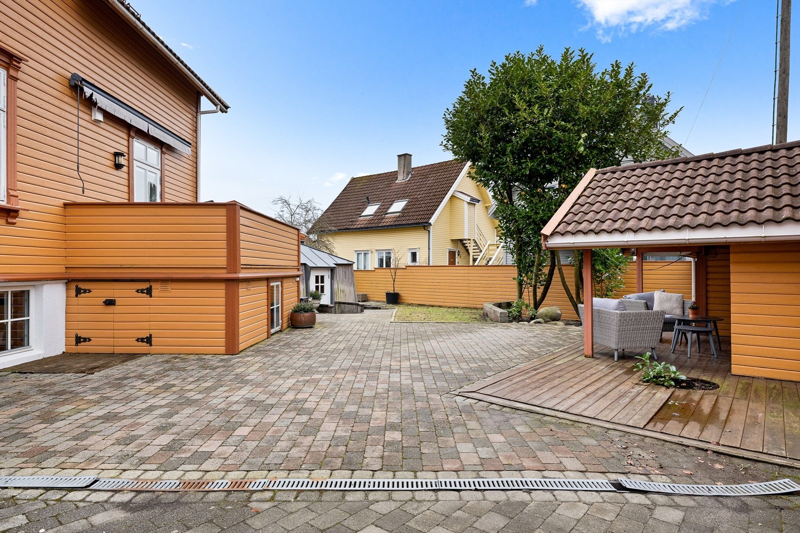 Tomten er felleseid mellom de to seksjonene og har en stor, steinsatt gårdsplass og skjermet hage. Uteområdet er delvis omkranset av teglsteinsmur mot gaten og mur/levegger mot naboer. Galleribilde