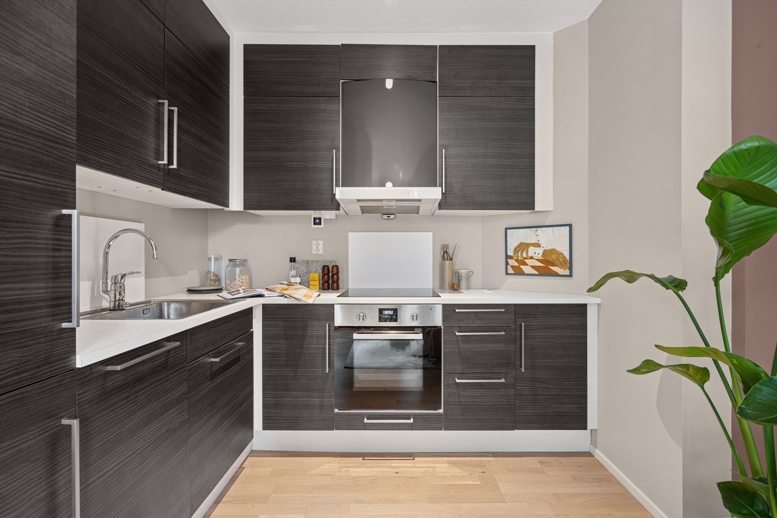 Kjøkkenet har en moderne innredning fra kvalitetsleverandøren Sigdal med glatte folierte fronter og laminat benkeplate med nedfelt kum i rustfritt stål. Galleribilde