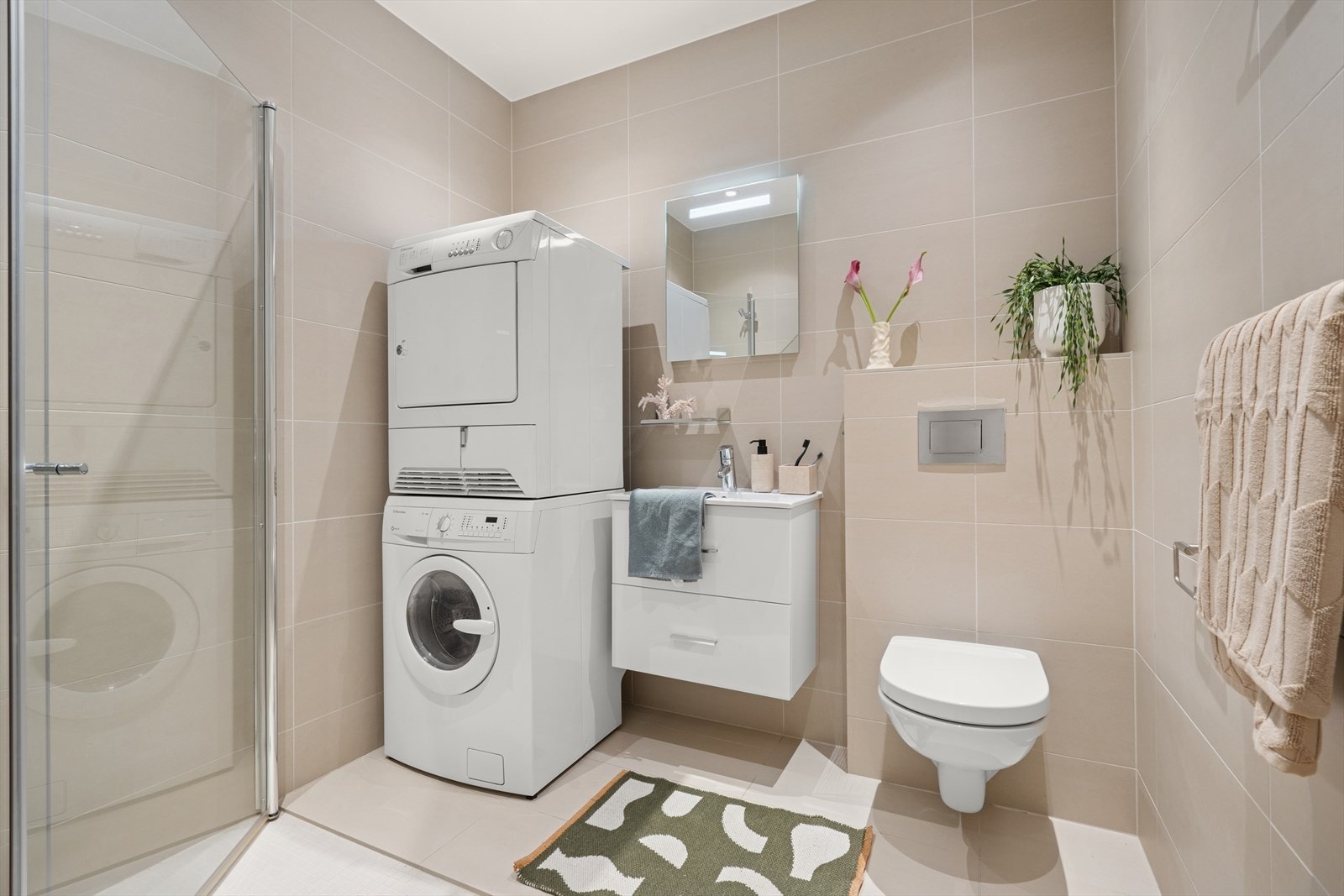 Rommet er innredet med vegghengt toalett, dusjhjørne m/innfellbare glassvegger, opplegg for vaskemaskin/tørketrommel og baderomsinnredning. Galleribilde