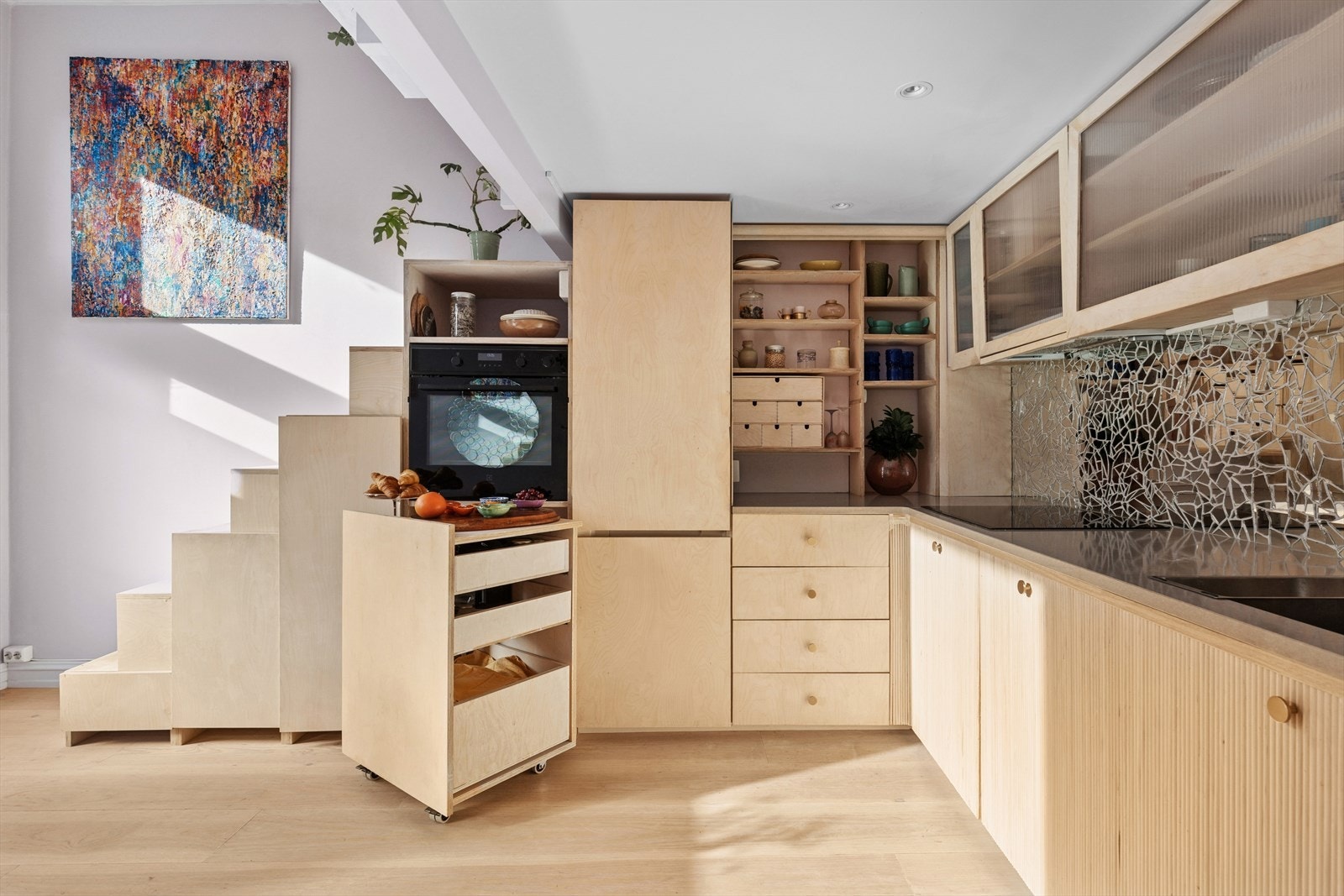 Kjøkkeninnredning med Ikea skrog, slette og profilerte fronter i finer, stein benkeplate m/speilfliser over, enkel underlimt kompositt oppvaskkum. Galleribilde