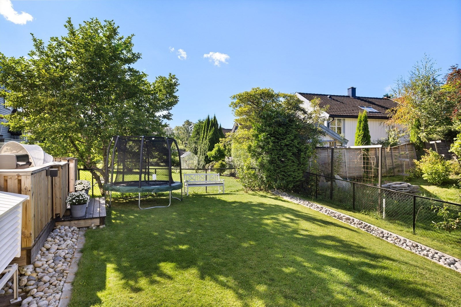 Pent opparbeidet og inngjerdet hage med plass til trampoline Galleribilde